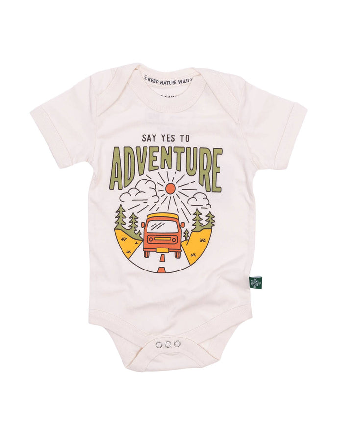 Close up of pale pink baby onesie featuring the Say Yes to Adventure text on the chest and the car and sun graphic