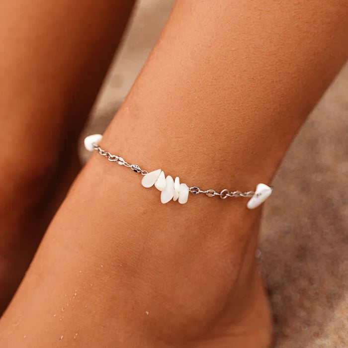 Close-up of Sea Treasures Anklet worn on the ankle with white shell beads along a silver chain