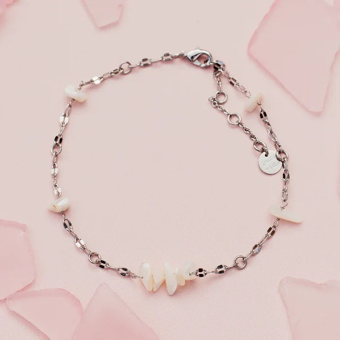 Sea Treasures Anklet with a delicate silver chain and small white shell charms on a pale pink background.