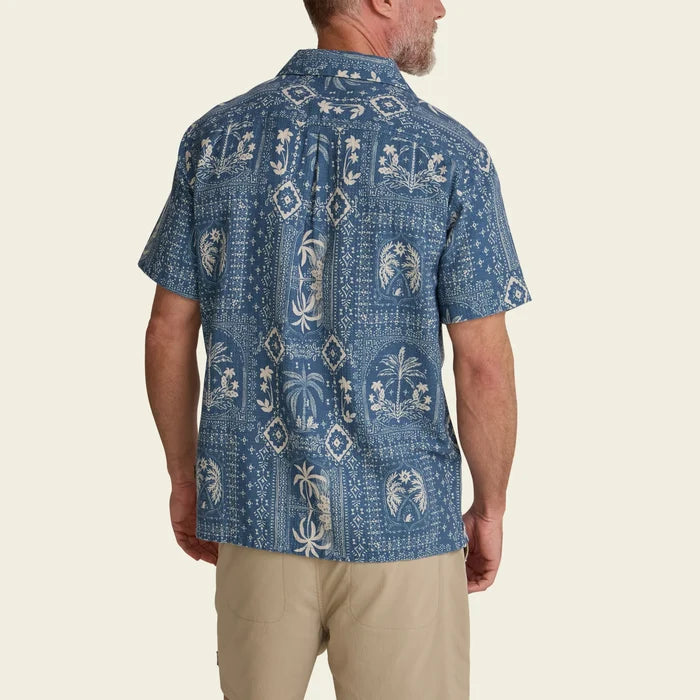 Back view of Shores Club Shirt in Palmetto Prophesy Storm Blue with tropical print and beige shorts
