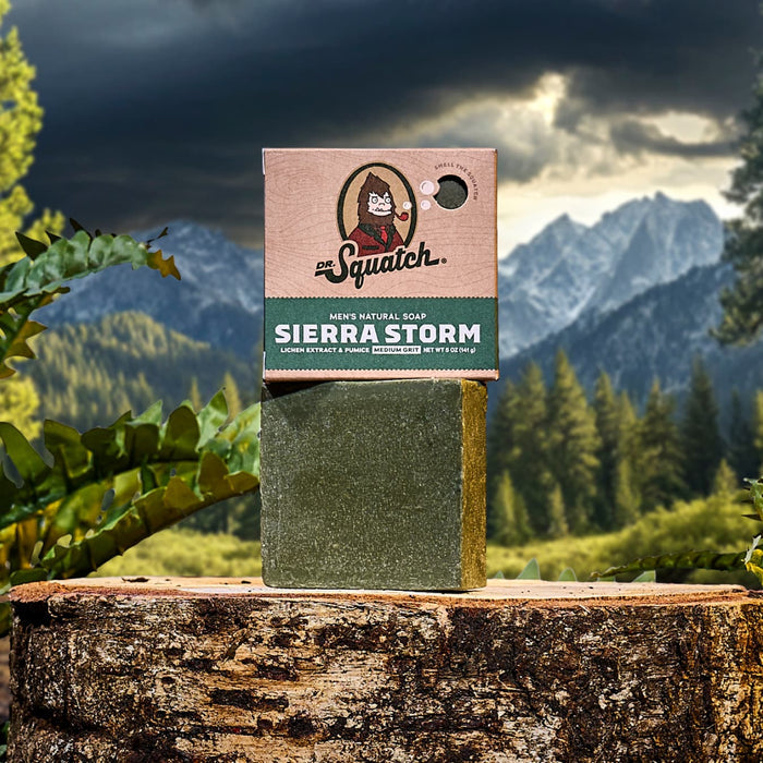 Dr Squatch Sierra Storm soap box atop a stone pillar with a mountain landscape in the background.