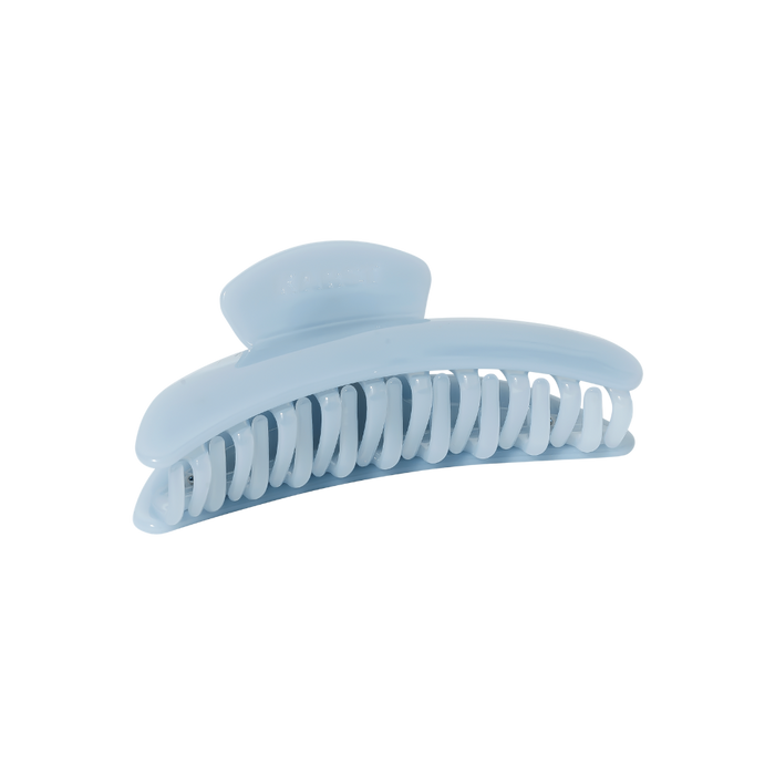 The Slim Hair Claw Clip — Mist by Karst Essentials is a sky blue cellulose acetate accessory with curved, interlocking teeth, displayed elegantly on a plain white background.