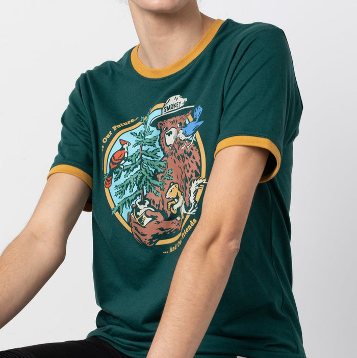 Close-up of Smokey's Friends Ringer Tee print on dark green fabric highlighting the forest scene with Smokey bear.