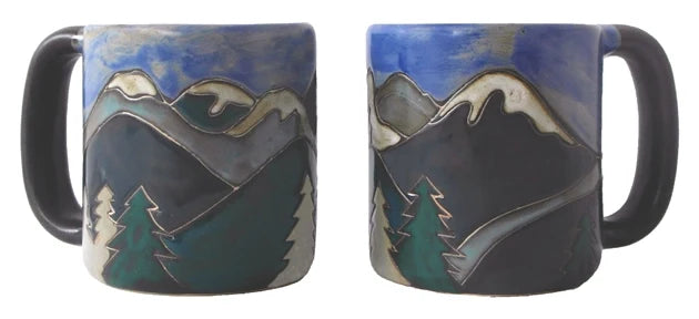 Two round stoneware mugs painted with a snowy mountain landscape and pine trees.