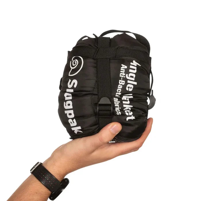 Snugpak Jungle Blanket XL in black packed and compressed in its stuff sack and held in someones hand to show the relative size