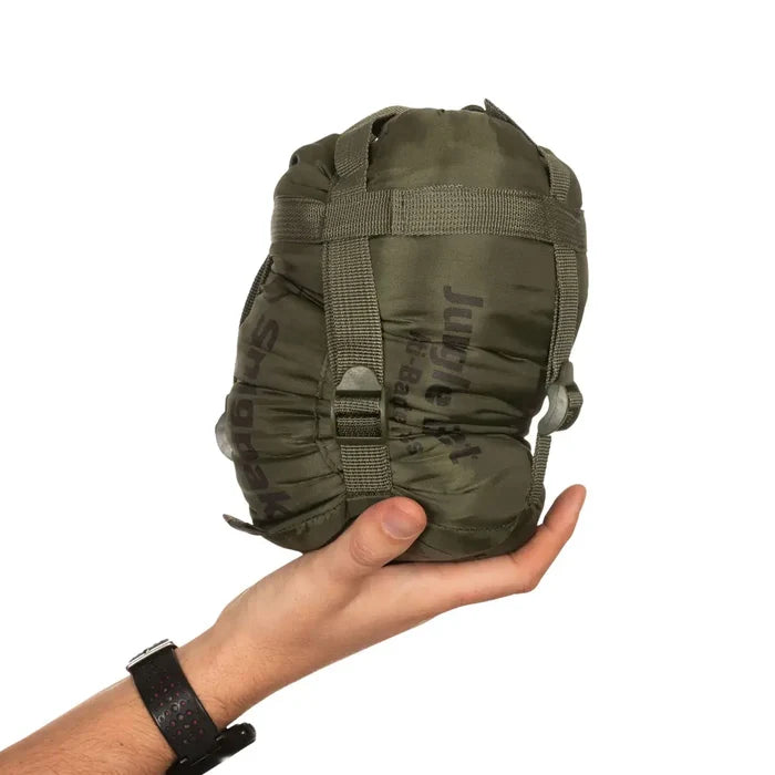 Snugpak Jungle Blanket XL in olive packed and compressed in its stuff sack and held in someones hand to show the relative size