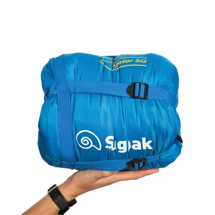 Snugpak Navigator 3-4 season sleeping bag in blue packed in its stuff sack and compressed using the integrated straps whilst being held in the palm of someones hand to show the relative size