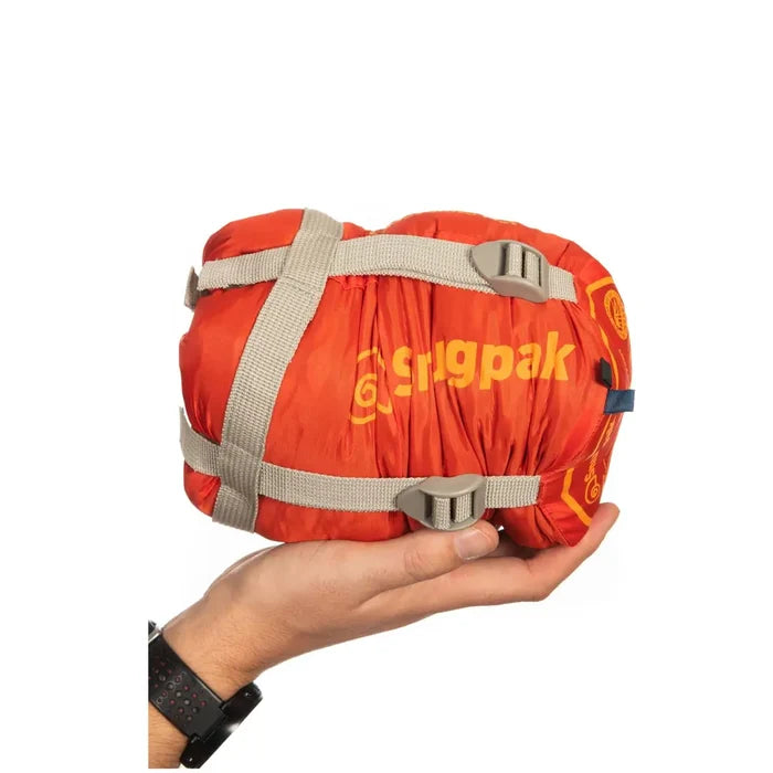 Studio shot on a white background of a hand holding a packed Snugpak Travelpak Traveller sleeping bag