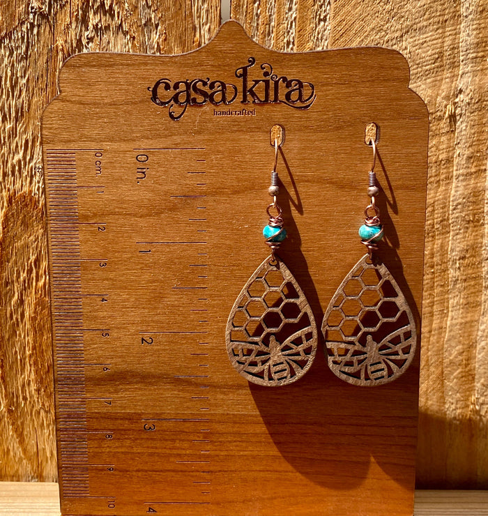 Earrings with turquoise beads and copper wire displayed on a wooden CasaKira handmade card