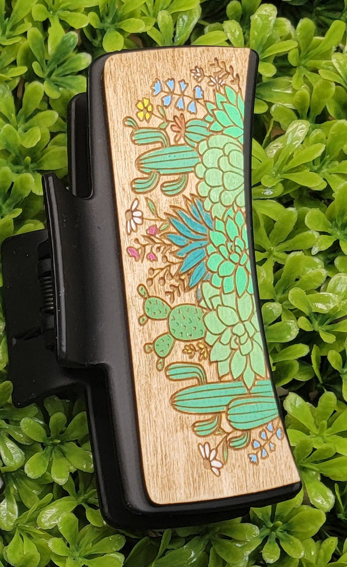 Wooden panel with colorful succulent and cactus illustration on a black claw clip