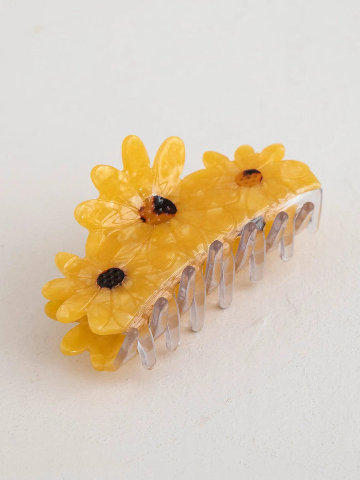 Sunflower shaped yellow hair clip with translucent petals and clear comb teeth