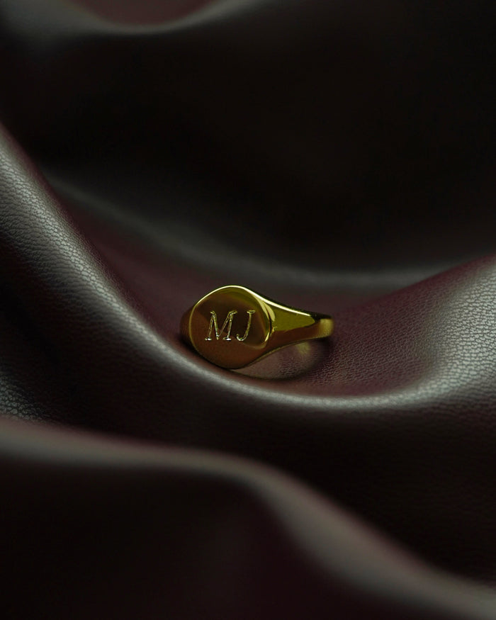 Close-up of Tessa signet ring with 'MJ' engraving, showcasing personalized jewelry and craftsmanship details.