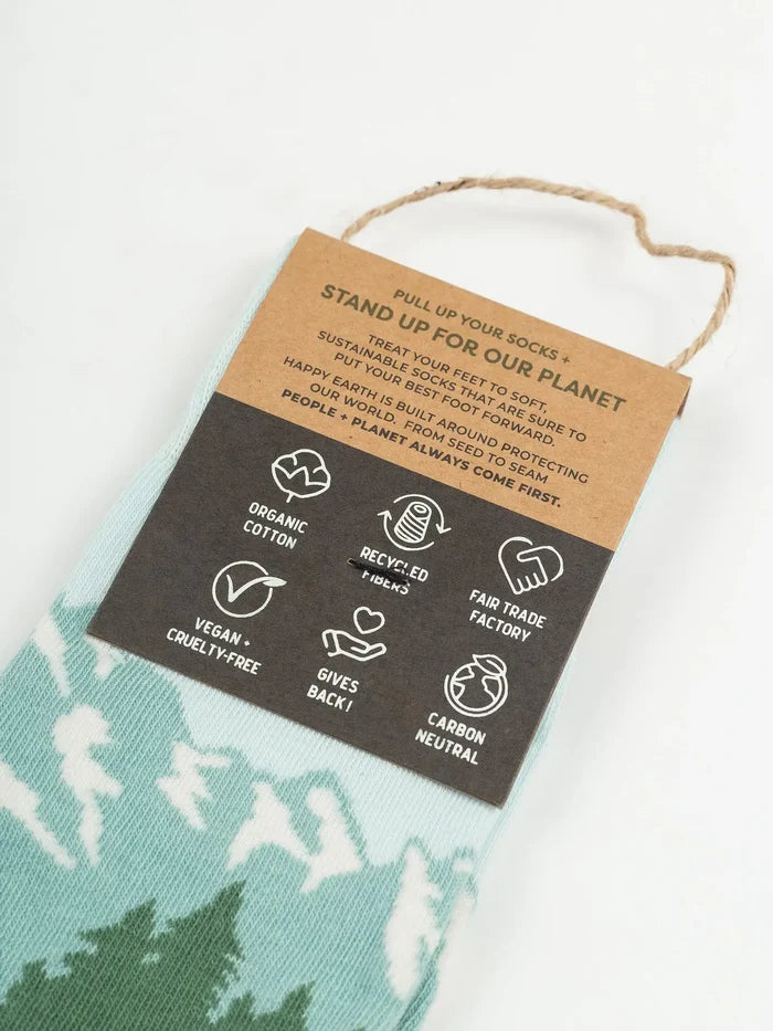 Close-up of pale blue Tetons Socks with a mountain motif and sustainability tag.