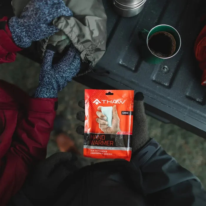 Lifestyle image of a Thaw disposbale hand warmer being held in someones hand whilst camping