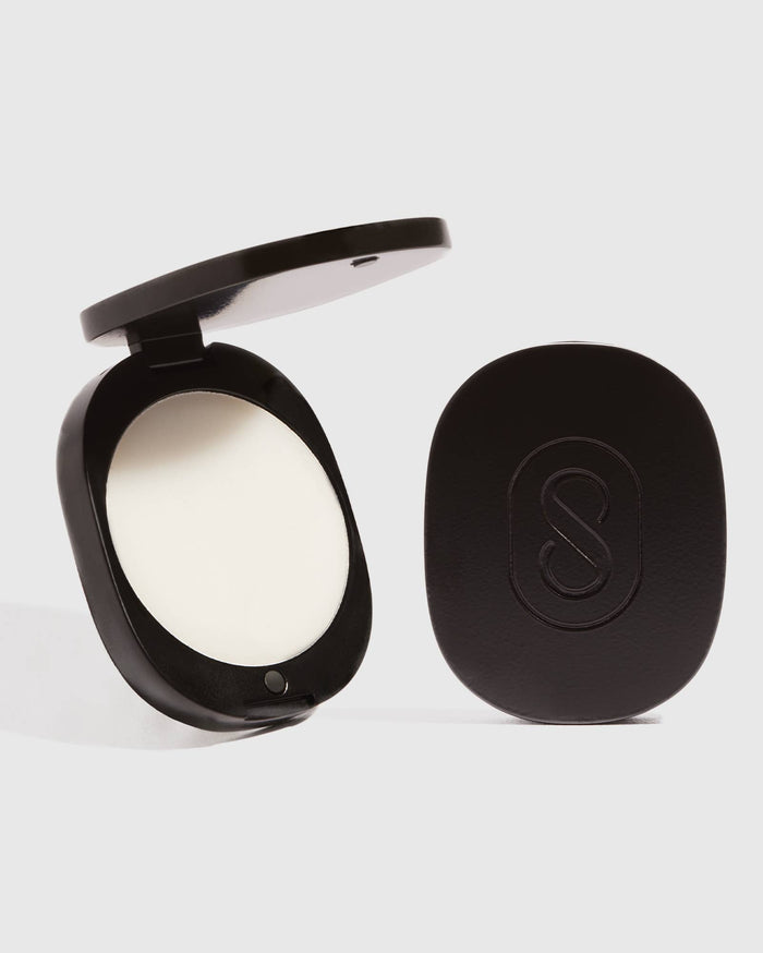 Compact powder with a black case on a white background