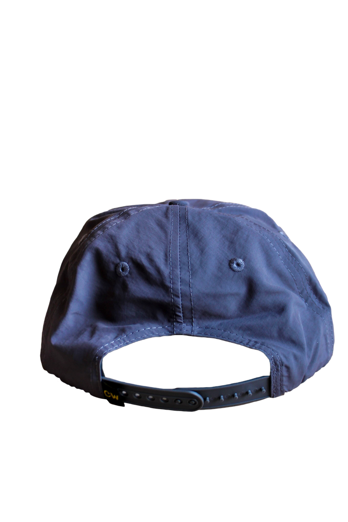 Rear view of a blue The Trout Hat showing an adjustable strap and stitched panels.