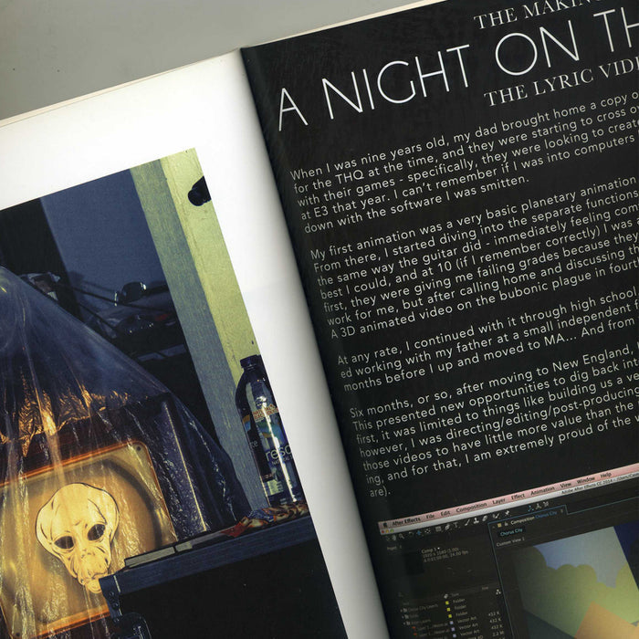 A magazine spread shows a close-up of a page with text about animation and photos of a desk featuring The Dear Hunters illuminated alien face decoration, partially veiled by translucent cloth—a scene fit for a stylish coffee table book.