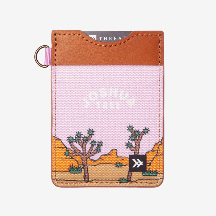 Pink desert landscape vertical wallet from National Parks collection with brown top and cactus canyon scene.