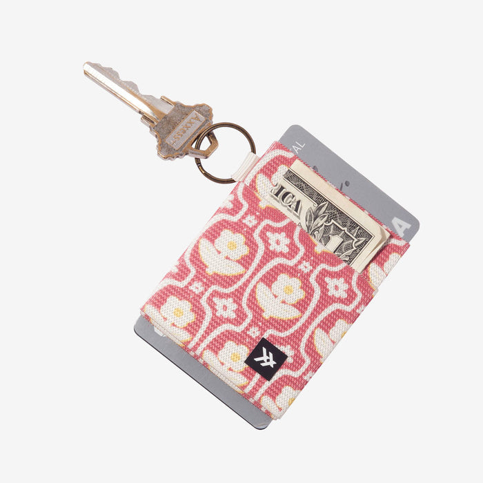 Pink floral Thread elastic wallet with key ring and card slot holding a dollar bill
