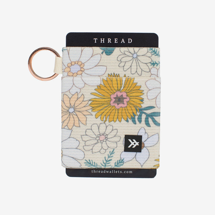 Floral patterned elastic wallet with cream background and multicolored flowers, attached to a gold key ring.