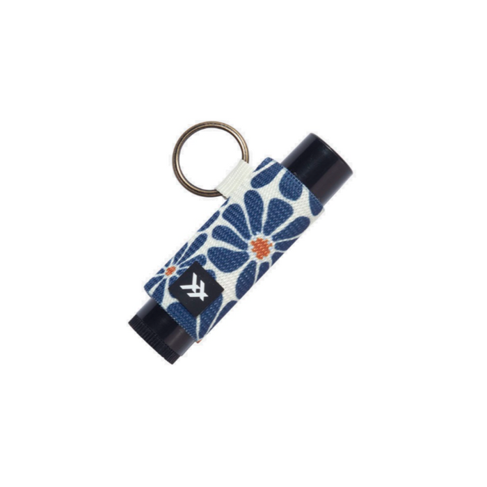 Lip balm holder wrapped in blue thread patterned fabric with a metal key ring