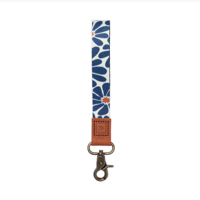 Blue and white floral thread patterned wrist lanyard with brown leather end and brass hardware