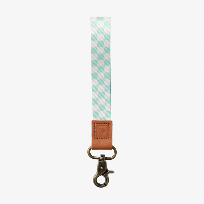 Teal and white checkered thread wrist lanyard with tan leather tab and brass clip