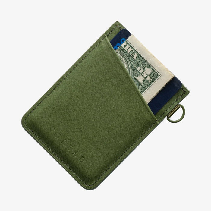 Olive green Thread vertical leather wallet showing a card and cash partially visible