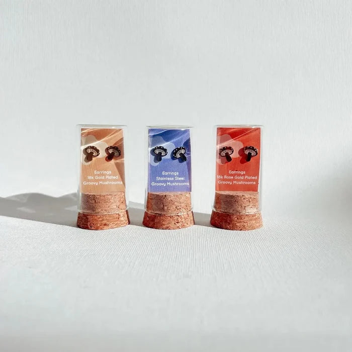 Three Tiny Groovy Mushrooms earrings boxes in orange blue and red with cork bases.