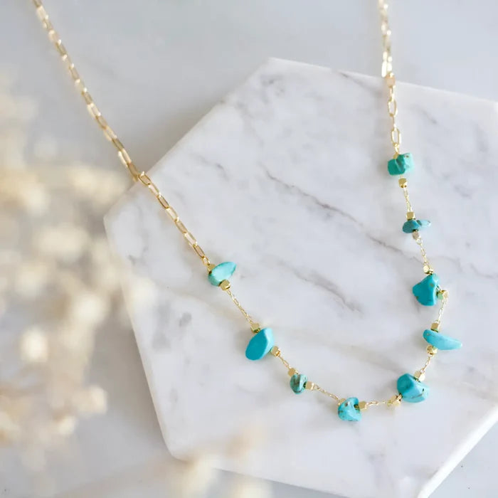 Delicate gold chain necklace with turquoise nugget beads along the chain