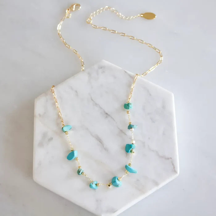 Gold chain necklace featuring turquoise nugget beads spaced along the chain