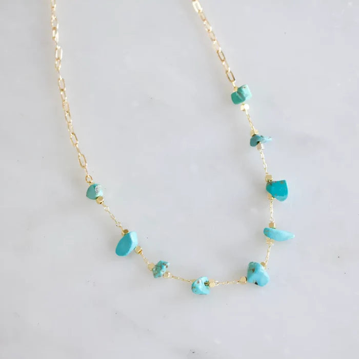 Gold chain necklace with turquoise nugget beads spaced along delicate links.
