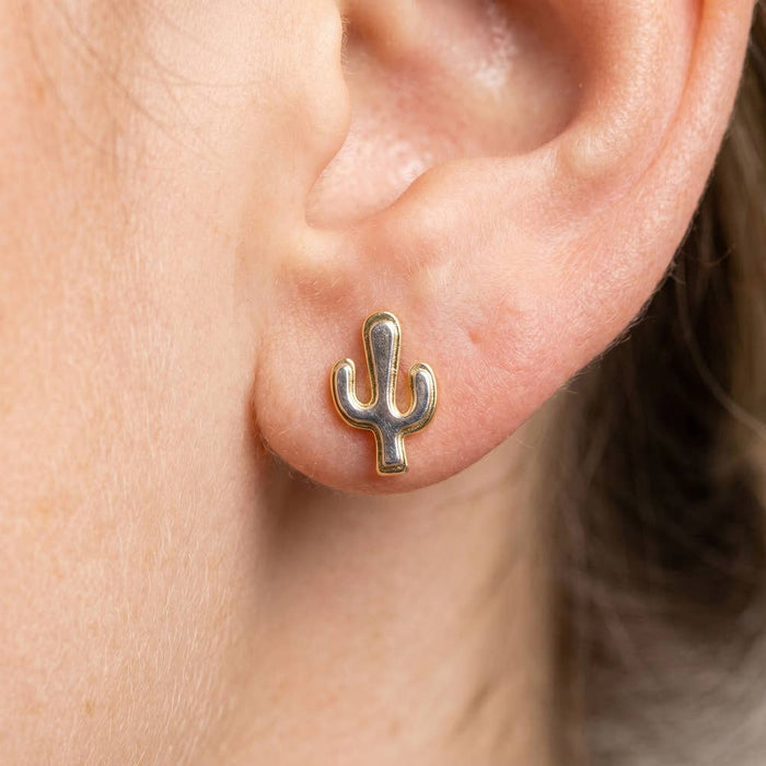 Two tone cactus stud earring in gold and silver worn on the earlobe.