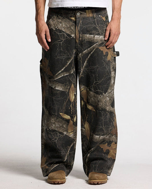 V1 CARPENTER PANTS REALTREE BLACK - black realtree camo carpenter pants, front view on male model - Cold Culture