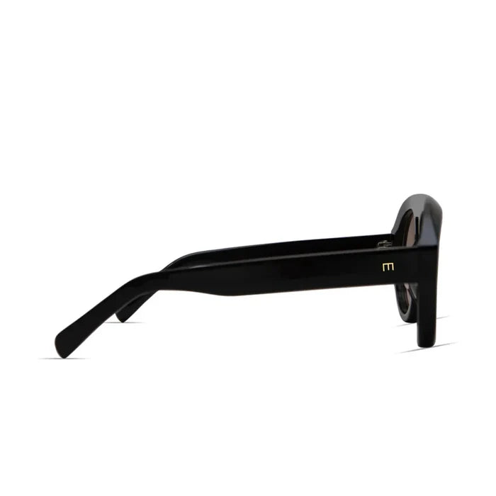 Side view of Val Sunglasses by Elisa Johnson—black acetate frames with thick arms, a small gold “M” logo near the hinge, and a glossy finish for a stylish, durable look. From Elisa Johnson.