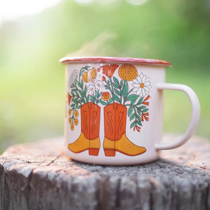 Enamel mug featuring orange Western boots surrounded by colorful flowers.