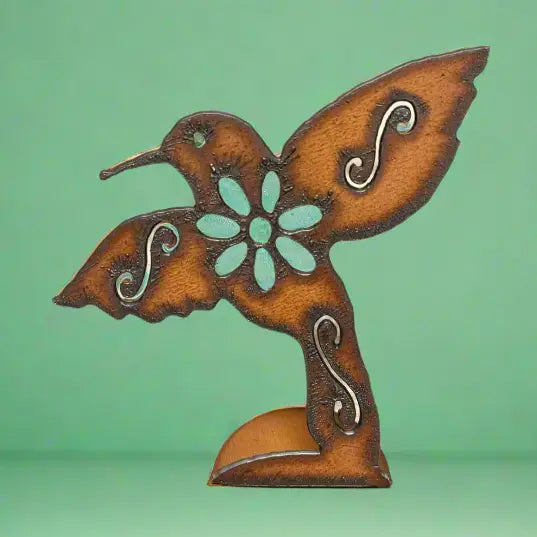 Rusty metal hummingbird standee with turquoise flower centerpiece on a green backdrop