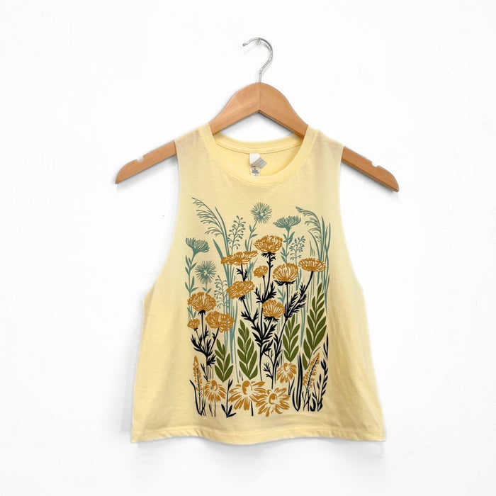 Creamy pale yellow crop tank on a hanger with dense yellow flowers and green foliage print