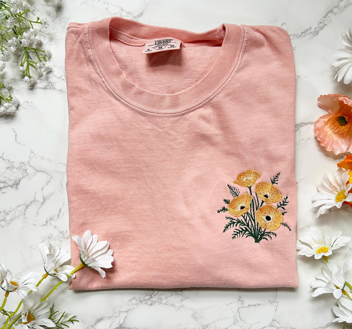 Soft pink Wild Poppies embroidered boxy crop tee with orange flowers along the hem.