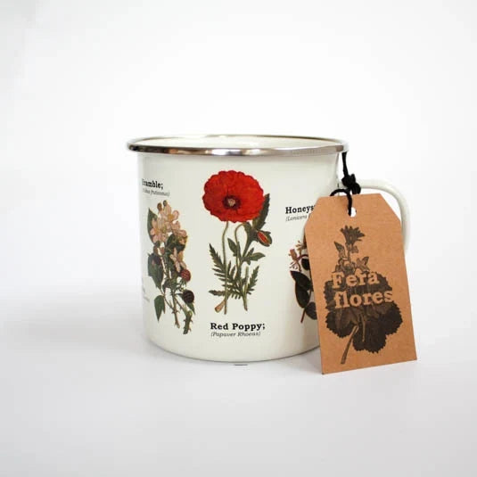Wildflowers enamel mug with a red poppy and other botanical illustrations and a brown attached tag.