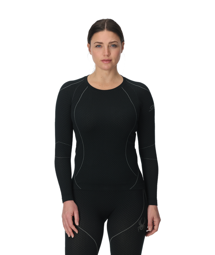 Woman wearing a black long-sleeve athletic outfit on a white background