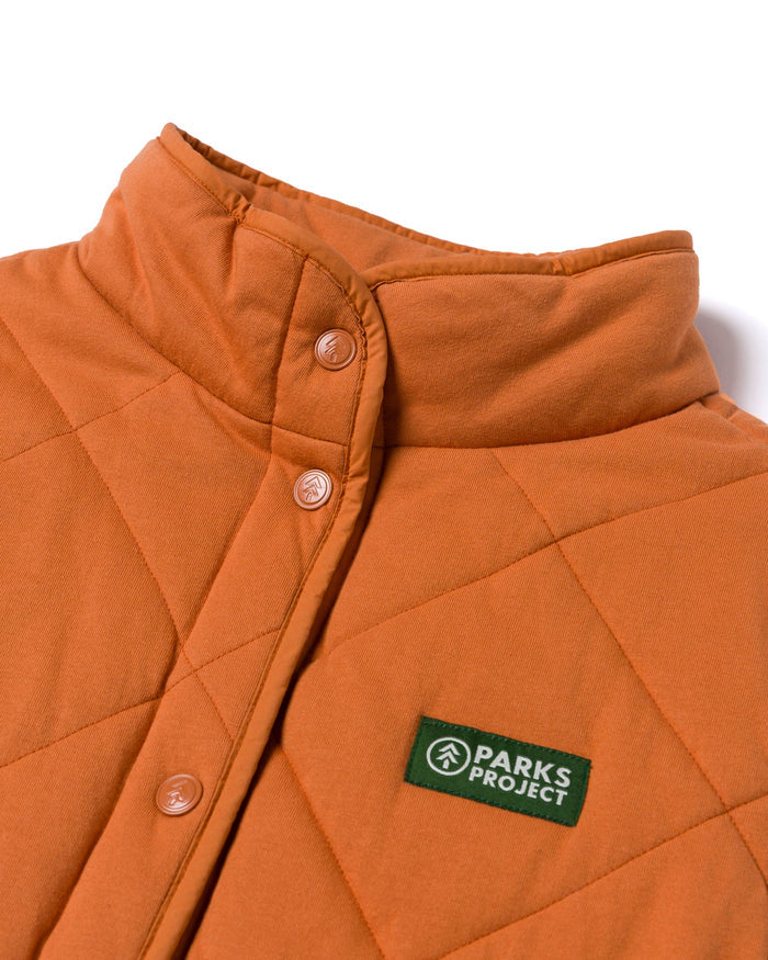 Close-up of collar and button placket on orange quilted vest.