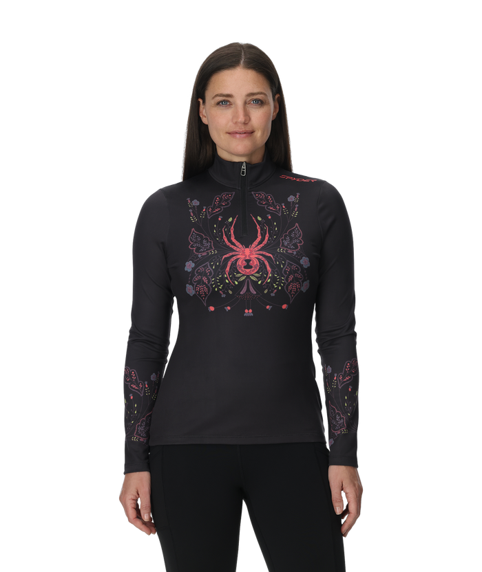 Woman wearing a black long-sleeve top with a colorful spider design on a white background