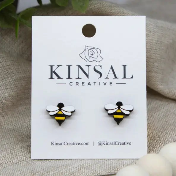 Wooden bumblebee earrings displayed on a white display card from Kinsal Creative.