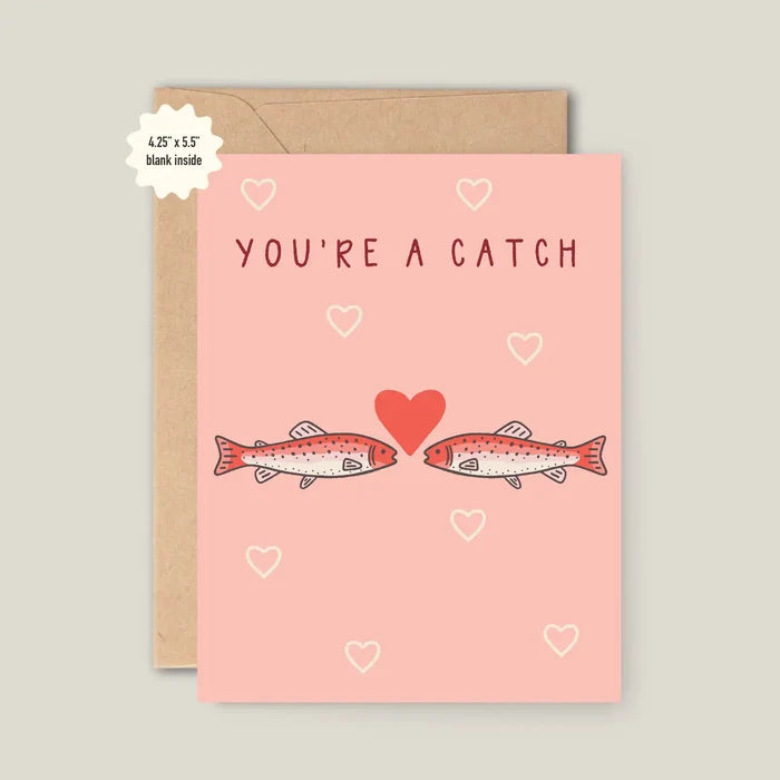 You're A Catch Valentine card with a pink cover featuring two fish facing each other and scattered hearts, shown with a kraft envelope.