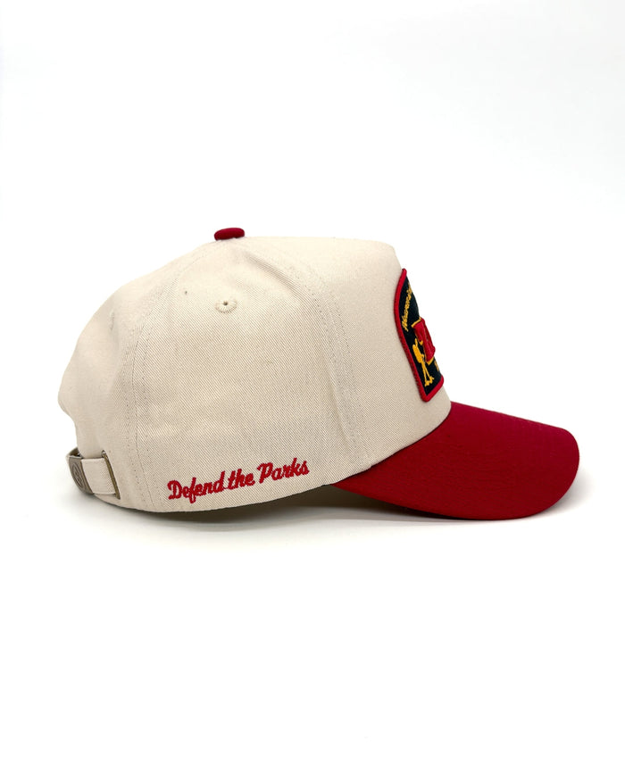Beige Zion Vintage Patch Hat shown from the side with a red brim and Defend the Parks embroidery